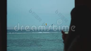 女人喝葡萄酒，看看人们如何<strong>风</strong>筝冲浪在美丽的<strong>清澈</strong>的水在达哈布埃及。 探索蓝色的大海